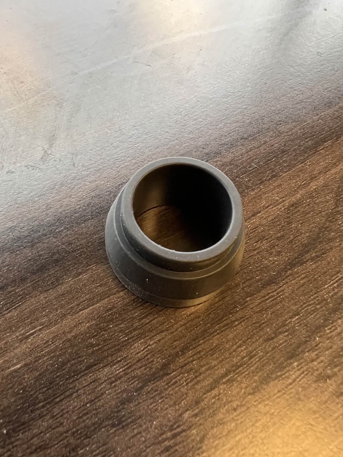 single small black injection molded rubber automotive grommet part prior to assembly